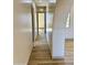 Hallway with hardwood floors and neutral walls, with archway and window at the end at 12942 S 218Th Ave, Buckeye, AZ 85326