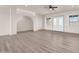 Spacious living room with wood flooring, an arched doorway, and ample natural light from windows at 12942 S 218Th Ave, Buckeye, AZ 85326