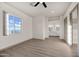 Spacious main bedroom with neutral floors and walls, ceiling fan, large window, and ensuite bathroom with double sinks at 12942 S 218Th Ave, Buckeye, AZ 85326