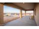Covered patio area with concrete flooring, offering scenic views of the surrounding desert landscape and neighboring houses at 12942 S 218Th Ave, Buckeye, AZ 85326