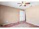 Bedroom features a ceiling fan, tile flooring, and ample closet space for storage at 1307 E Galvin St, Phoenix, AZ 85086