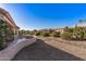 Beautiful backyard with desert landscaping, a curved retaining wall, and views of neighboring homes and palm trees at 14218 W Via Tercero --, Sun City West, AZ 85375