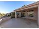 Covered patio with views into the well-maintained backyard, with a curved privacy wall, and sliding glass doors at 14218 W Via Tercero --, Sun City West, AZ 85375
