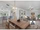 Open-concept dining area with a large wooden table, chandelier, connecting seamlessly to the modern kitchen at 14218 W Via Tercero --, Sun City West, AZ 85375