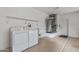 Garage laundry area featuring a washer, dryer, utility sink, shelving and water heater, all in a clean, functional space at 14218 W Via Tercero --, Sun City West, AZ 85375