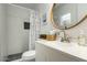 Well-lit bathroom with a large round mirror, modern fixtures, and a decorative shower curtain at 14436 N 34Th Pl, Phoenix, AZ 85032