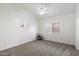 Bedroom features neutral carpet, a ceiling fan, natural light, and minimalistic wall art at 14610 N 87Th Ave, Peoria, AZ 85381