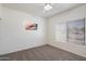 Bedroom features neutral carpet, a ceiling fan, natural light, and simple artwork at 14610 N 87Th Ave, Peoria, AZ 85381