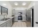 Modern kitchen with stainless steel appliances, gray cabinets, and tile flooring at 14610 N 87Th Ave, Peoria, AZ 85381