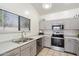 Well-lit kitchen featuring stainless steel appliances, gray cabinets, and a double basin sink at 14610 N 87Th Ave, Peoria, AZ 85381