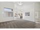 Bright living room featuring neutral carpeting, modern ceiling fan, and vaulted ceilings at 14610 N 87Th Ave, Peoria, AZ 85381