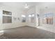 Spacious living room featuring plush carpeting, many windows, and a modern ceiling fan at 14610 N 87Th Ave, Peoria, AZ 85381