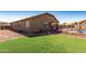 Expansive artificial grass backyard with pool, patio, and desert landscaping at 14846 N 145Th Ave, Surprise, AZ 85379