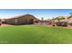 Artificial grass backyard with pool, covered patio, and desert landscaping at 14846 N 145Th Ave, Surprise, AZ 85379