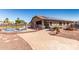 Paver patio and lush backyard with pool, barbecue, trampoline, and dining area at 14846 N 145Th Ave, Surprise, AZ 85379