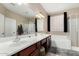 Bright bathroom with double vanity, large mirror, separate tub and shower, and neutral tones at 14846 N 145Th Ave, Surprise, AZ 85379