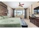 Comfortable main bedroom featuring natural light and a glimpse into the bathroom and television at 14846 N 145Th Ave, Surprise, AZ 85379