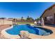 Sparkling blue pool with rock features and sunning chairs at 14846 N 145Th Ave, Surprise, AZ 85379