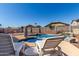 Outdoor inground pool with rock waterfall feature and poolside lounge chairs at 14846 N 145Th Ave, Surprise, AZ 85379