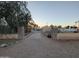 Desert home featuring stone columns with driveway and lush, mature trees at 150 N 65Th St, Mesa, AZ 85205