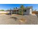 View of the backyard with rock landscaping, a covered patio, and a view of the exterior of the home at 15028 N 35Th Ave, Phoenix, AZ 85053