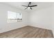 Empty bedroom features wood-style floors, a ceiling fan, and a window for natural light at 15028 N 35Th Ave, Phoenix, AZ 85053