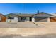 Charming single-story home with a gravel yard, wide driveway, and a gray two-car garage at 15028 N 35Th Ave, Phoenix, AZ 85053