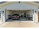 View of a clean and organized garage with a vehicle, lawn equipment, and ample storage space at 15028 N 35Th Ave, Phoenix, AZ 85053