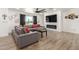 Modern living room with a large gray couch, flat-screen television, and elegant wood flooring at 15028 N 35Th Ave, Phoenix, AZ 85053