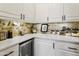 Well-organized kitchen counter with white cabinets, quartz countertop, brick backsplash, and modern appliances at 15240 N Clubgate Dr # 160, Scottsdale, AZ 85254