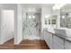 Bathroom featuring double sinks, granite counters, and a luxurious glass-enclosed shower at 16189 N 137Th Dr, Surprise, AZ 85374