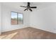 Bright bedroom featuring carpeted floors, a ceiling fan, and a view from a large window at 16189 N 137Th Dr, Surprise, AZ 85374