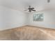 Spacious bedroom with neutral carpet, ceiling fan, and a large window at 16189 N 137Th Dr, Surprise, AZ 85374