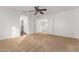 Spacious bedroom with neutral carpet, ceiling fan, and a view into another room at 16189 N 137Th Dr, Surprise, AZ 85374