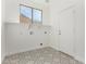 Bright laundry room with ample shelf space and stylish patterned tile flooring at 16189 N 137Th Dr, Surprise, AZ 85374