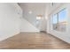 Open-concept living room with hardwood floors and a modern chandelier at 16189 N 137Th Dr, Surprise, AZ 85374