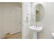 Clean bathroom with a pedestal sink, oval mirror, and access to additional room at 16372 W Mulberry Dr, Goodyear, AZ 85395