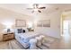 Bedroom with a bed, white bedding, bedside tables with lamps, three decorative ottomans, and area rug at 16372 W Mulberry Dr, Goodyear, AZ 85395