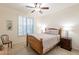 Cozy bedroom featuring a wooden bed frame, ceiling fan, and bright natural light at 16372 W Mulberry Dr, Goodyear, AZ 85395
