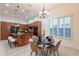 The dining area with decorative chandelier, set table, and chairs, with kitchen island and bar seating nearby at 16372 W Mulberry Dr, Goodyear, AZ 85395