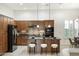 A gourmet kitchen with a center island, bar stool seating, granite countertops, mosaic backsplash, and stainless steel appliances at 16372 W Mulberry Dr, Goodyear, AZ 85395
