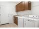 Functional laundry room with modern washer and dryer, cabinetry, and sink at 16372 W Mulberry Dr, Goodyear, AZ 85395