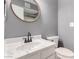 Updated bathroom with a round mirror, white vanity, and bronze fixtures at 1718 S Longmore -- # 41, Mesa, AZ 85202