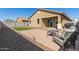 Home's backyard features a lounge set, gravel area, and a patch of well-maintained artificial turf at 17583 W Paraiso Dr, Surprise, AZ 85387