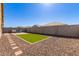 Well-maintained backyard with a patio seating area, artificial grass, and gravel landscaping at 17583 W Paraiso Dr, Surprise, AZ 85387