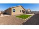 Home's backyard with a patio set, gravel, and well-maintained artificial grass, ideal for relaxing at 17583 W Paraiso Dr, Surprise, AZ 85387