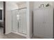 Bright bathroom featuring a clear glass shower enclosure and gray storage cabinets at 17583 W Paraiso Dr, Surprise, AZ 85387