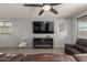 Bright living room featuring a large TV mounted above a fireplace and a view of the front yard at 17583 W Paraiso Dr, Surprise, AZ 85387
