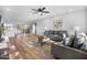 Bright living room featuring hardwood floors, modern ceiling fan, and comfortable gray sofas at 17615 N Whispering Oaks Dr, Sun City West, AZ 85375