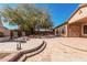 Backyard featuring an outdoor fireplace, a shade tree, and ample patio space at 19405 W Oregon Ave, Litchfield Park, AZ 85340